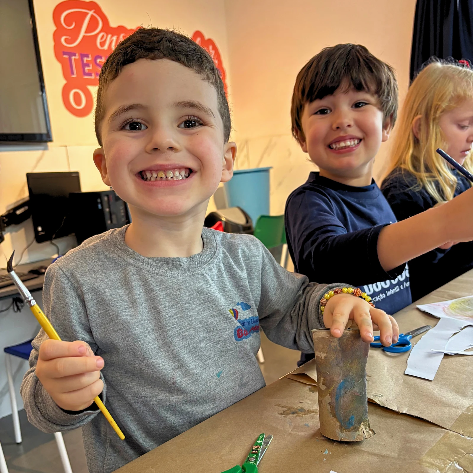 Alunos participando de uma atividade artística com pincéis e materiais