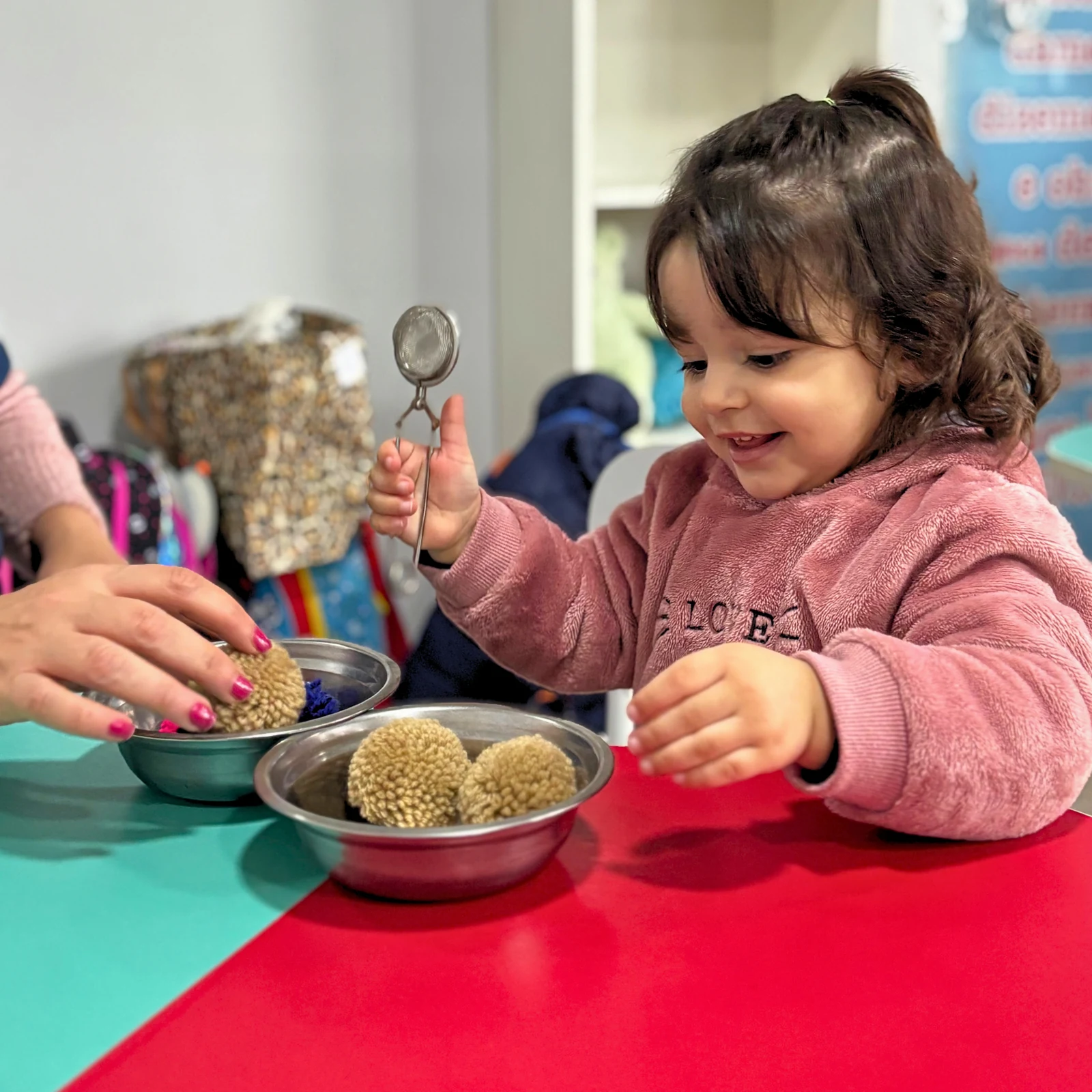 Criança explorando materiais e utensílios em uma atividade sensorial