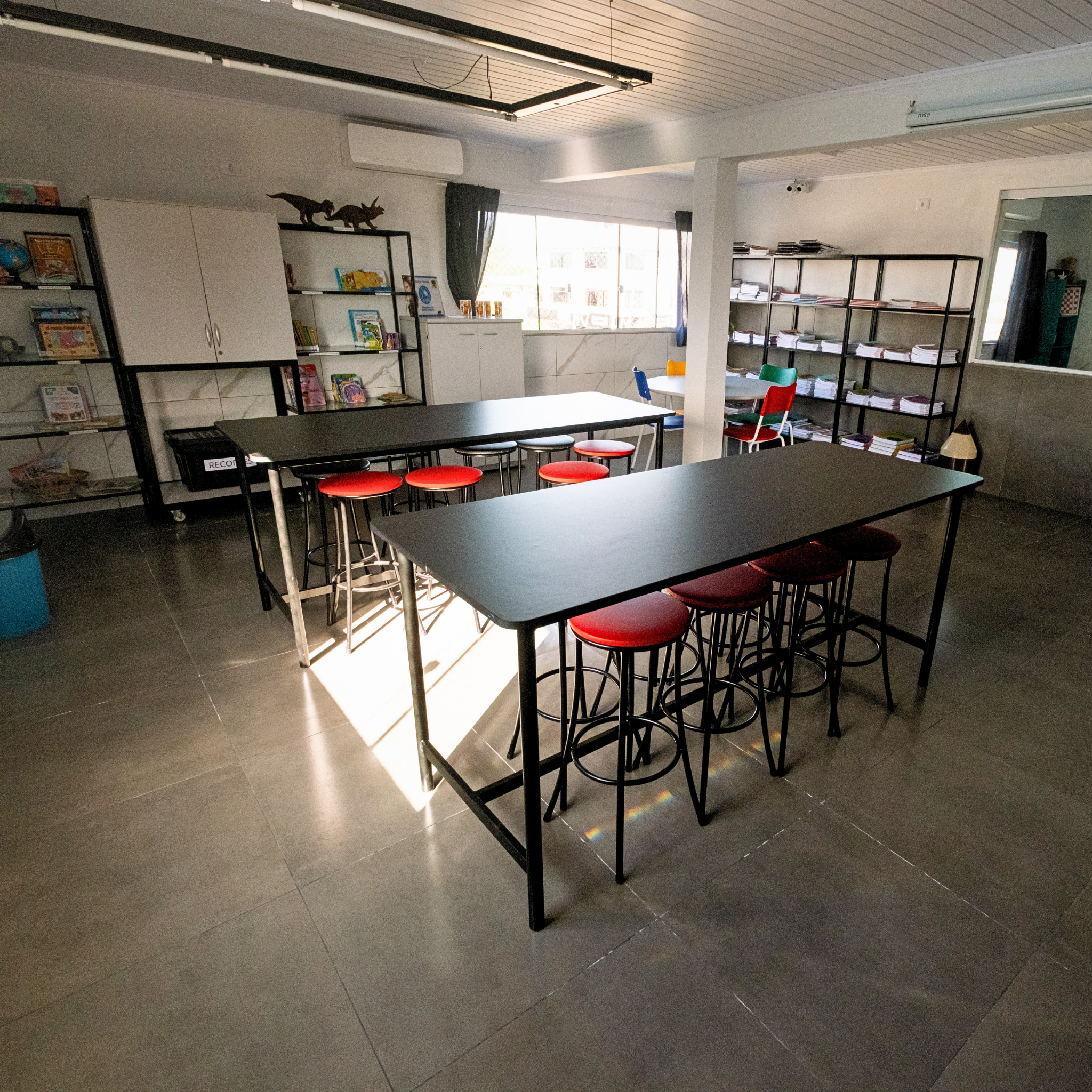 Ambiente pedagógico da Escola São José com mesas e materiais